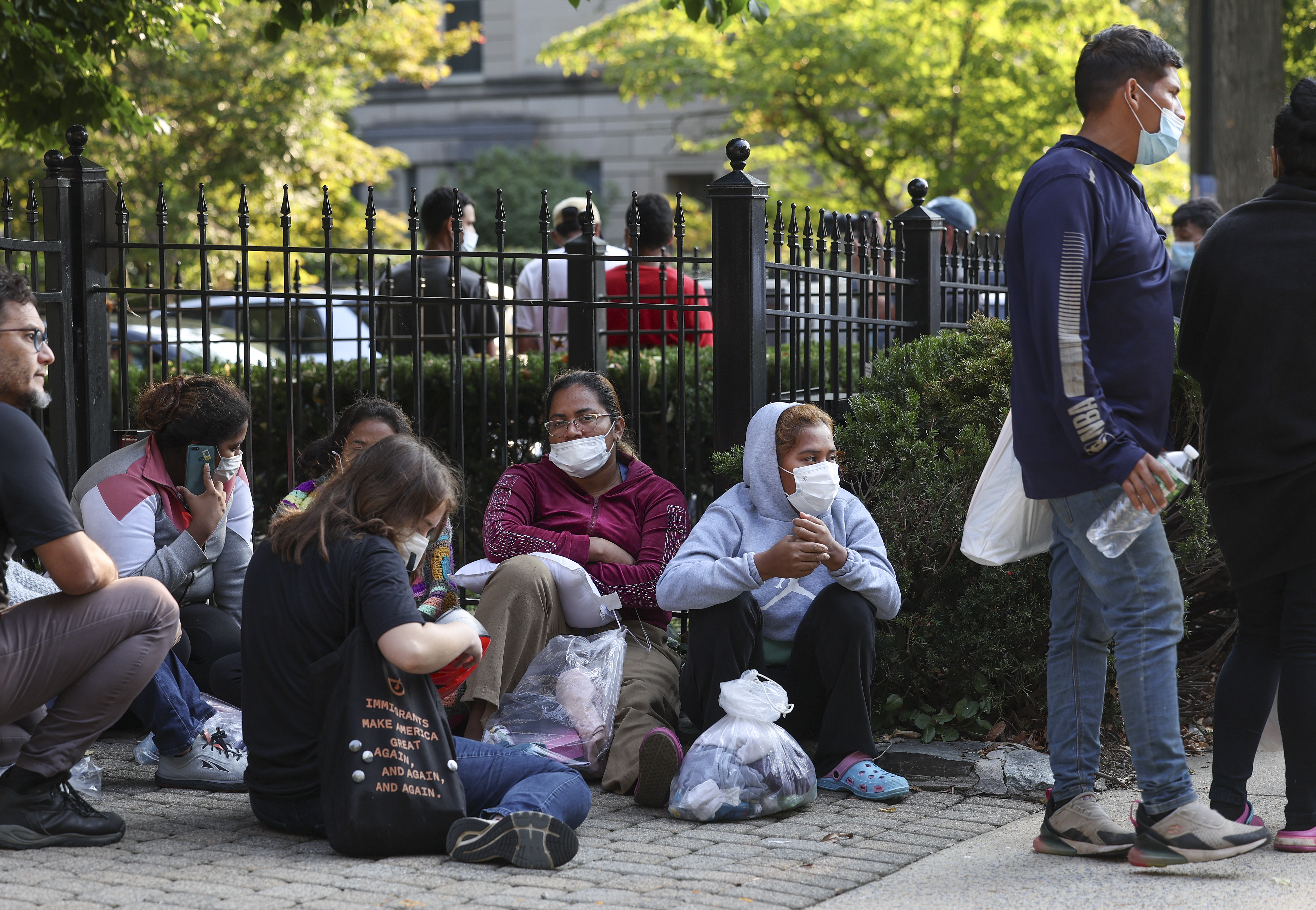 Migrants from Central and South America wait near the residence of Vice President Kamala Harris after being dropped off on Sept. 15, 2022, in Washington, D.C.